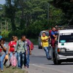 En cadena humana, caravana migrante llega a puente fronterizo Guatemala- México